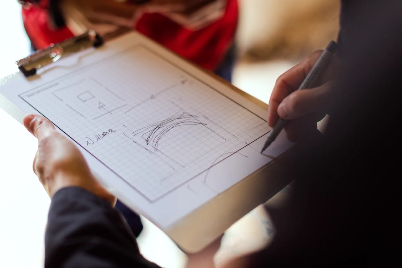 An engineer sketching a technical diagram on a clipboard