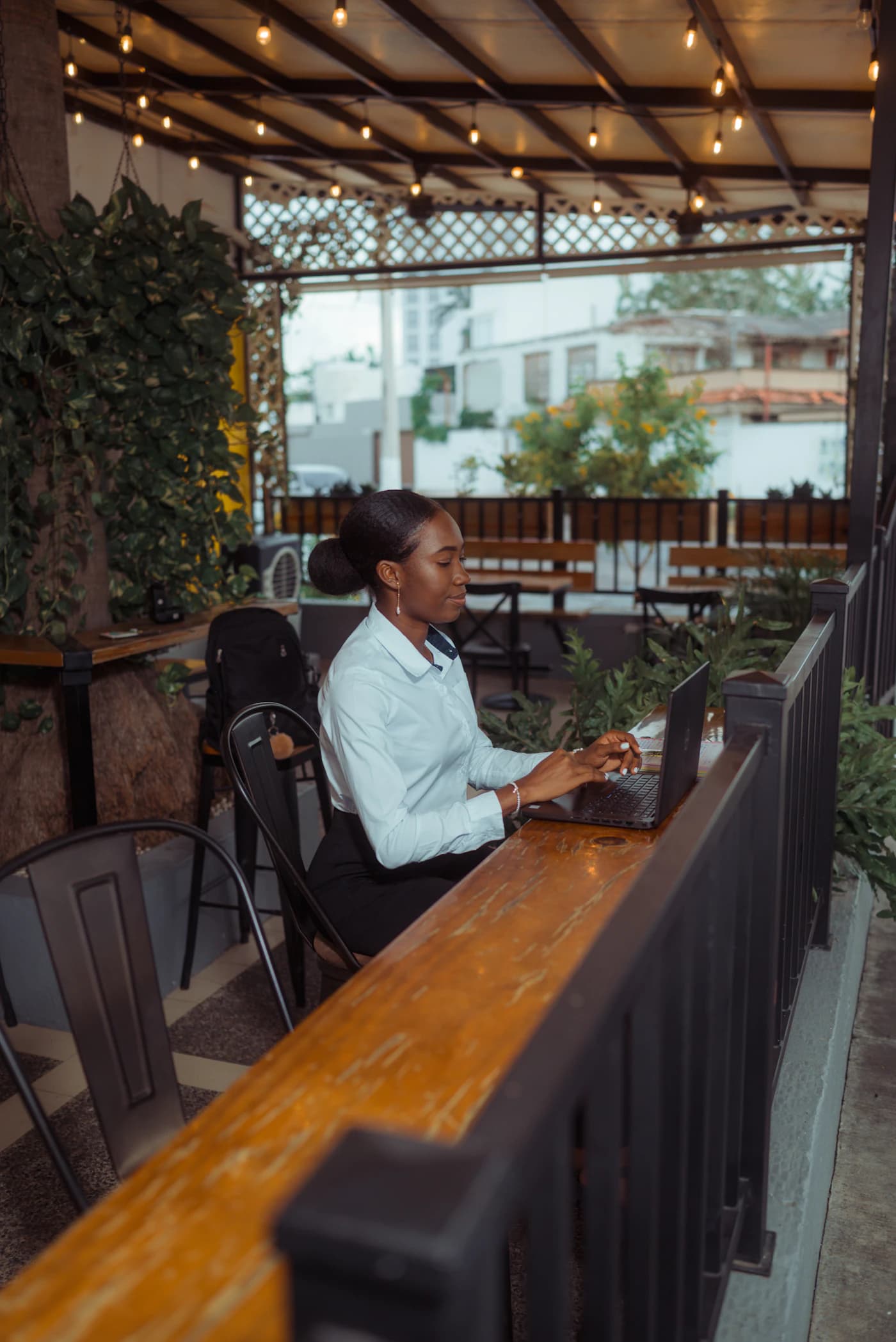 A small-business owner working on a laptop at an outdoor cafe