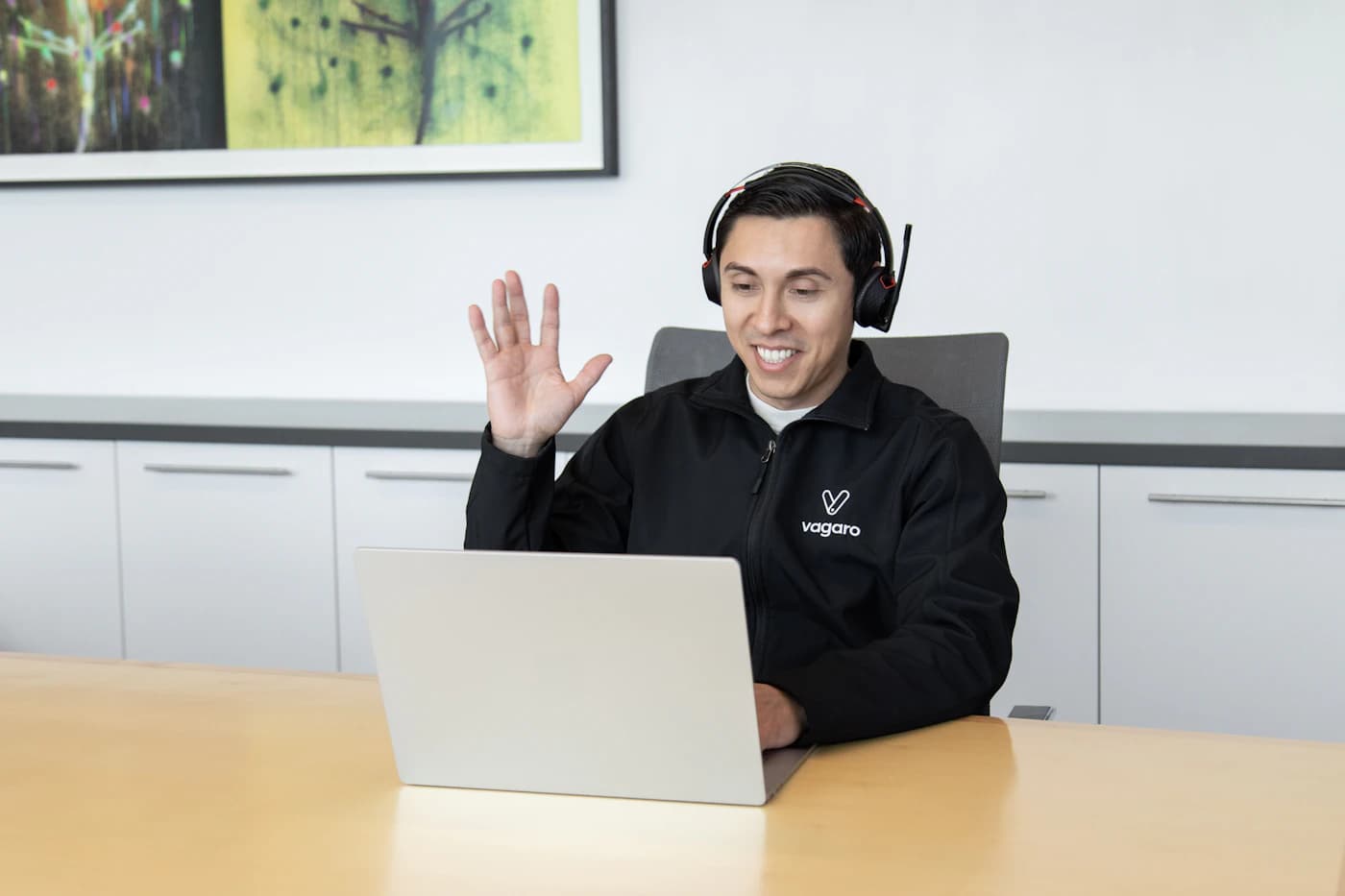 A customer support representative wearing a headset at a laptop